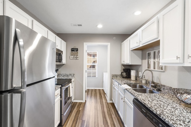 kitchen featuring appliances with stainless steel finishes, dark hardwood / wood-style floors, and white cabinets