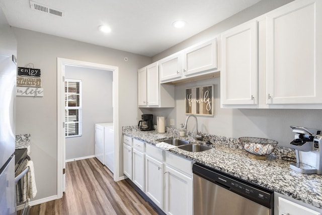 kitchen featuring washing machine and clothes dryer, sink, dark hardwood / wood-style floors, white cabinets, and appliances with stainless steel finishes