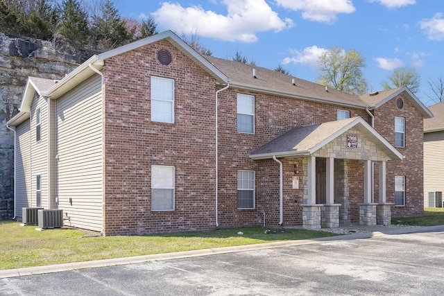 view of front of home featuring a front yard and central AC unit