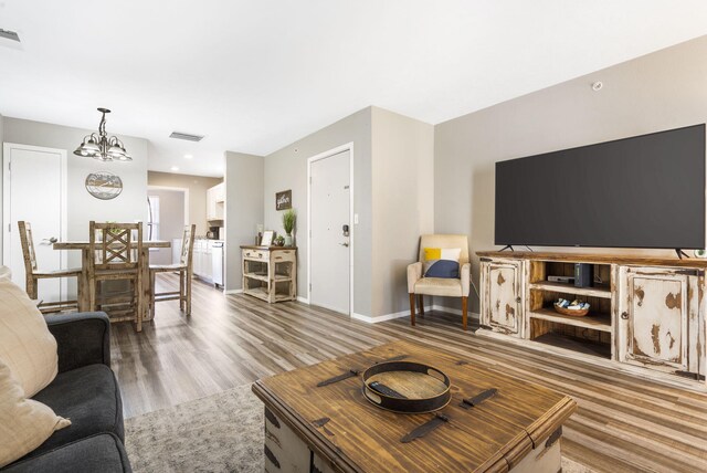 living room with hardwood / wood-style floors and an inviting chandelier