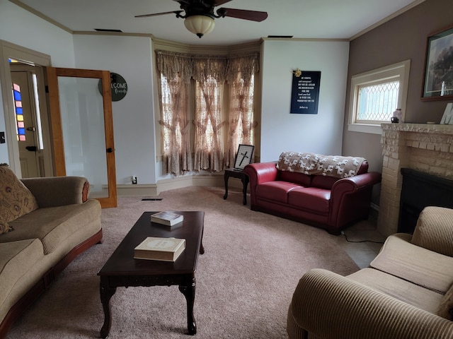 living room featuring ornamental molding, a fireplace, ceiling fan, and light colored carpet