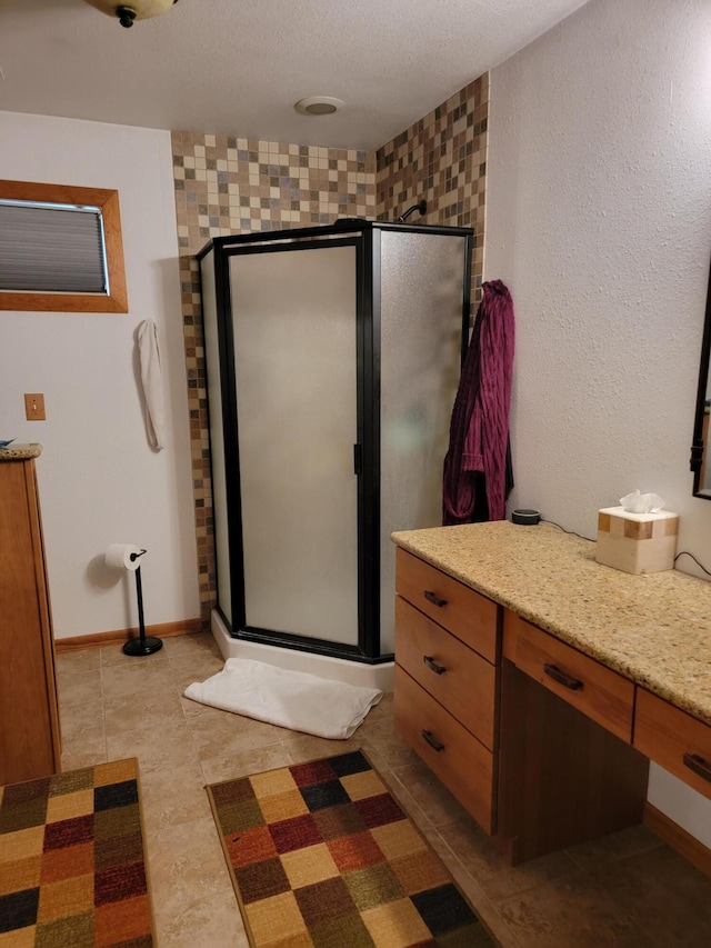 bathroom featuring tile patterned flooring, a shower with door, and vanity