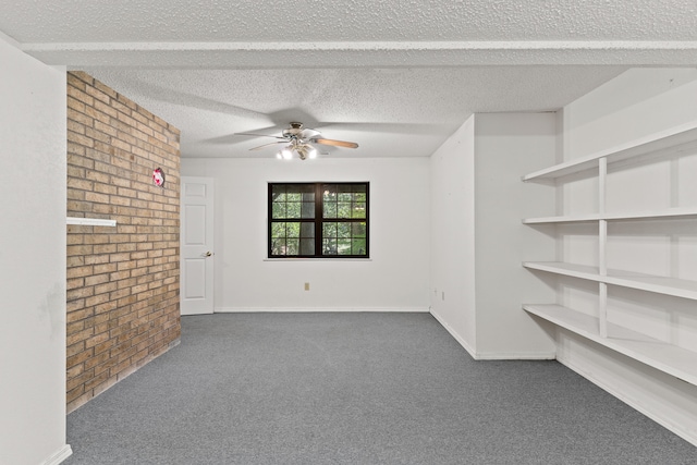 carpeted spare room with brick wall, a textured ceiling, and ceiling fan