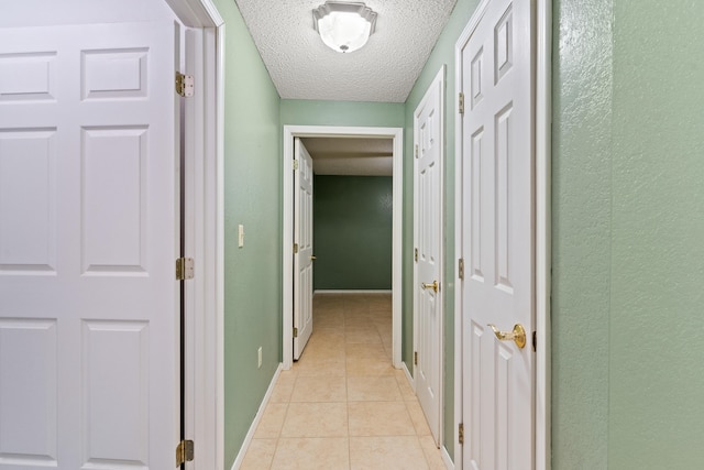 hall with light tile patterned floors and a textured ceiling