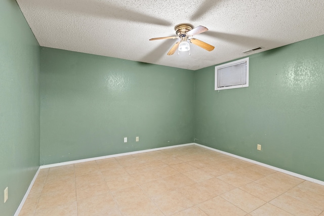 empty room with ceiling fan and a textured ceiling