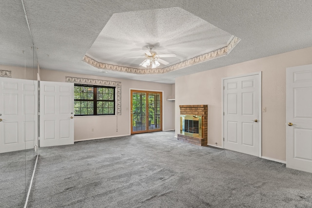 unfurnished living room featuring a textured ceiling, a raised ceiling, and carpet flooring