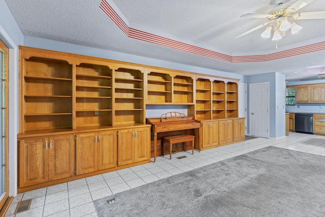 unfurnished office featuring ceiling fan, light colored carpet, and a textured ceiling