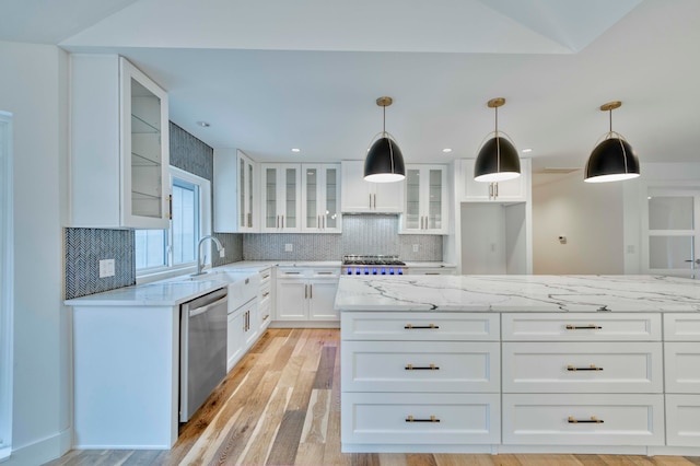 kitchen featuring light stone counters, stainless steel dishwasher, light hardwood / wood-style floors, hanging light fixtures, and white cabinetry