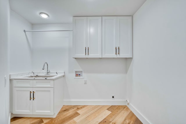 clothes washing area featuring cabinets, light wood-type flooring, hookup for a washing machine, sink, and electric dryer hookup