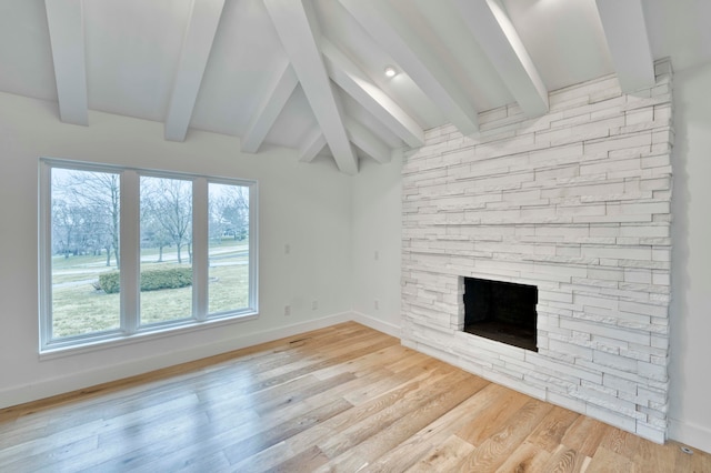 unfurnished living room featuring light wood-type flooring, a fireplace, and beam ceiling