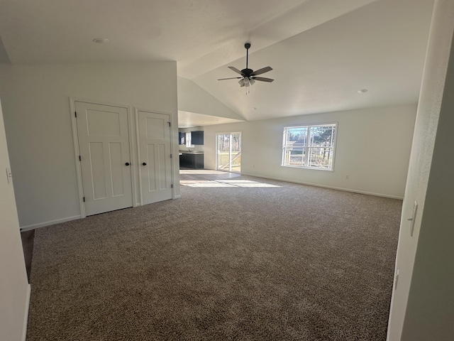 unfurnished living room featuring carpet floors, vaulted ceiling, baseboards, and ceiling fan