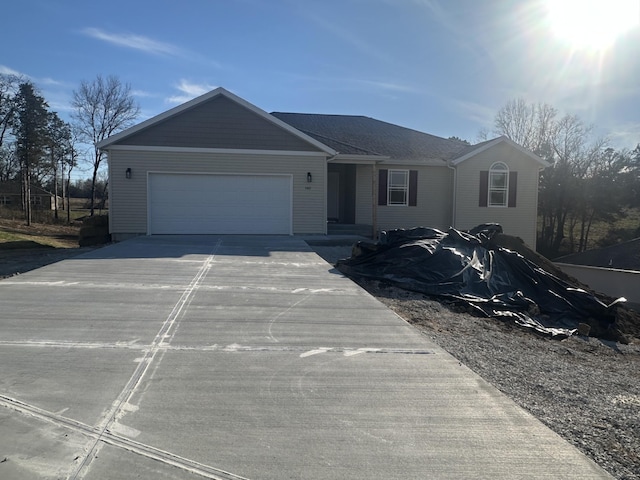 single story home featuring concrete driveway and an attached garage