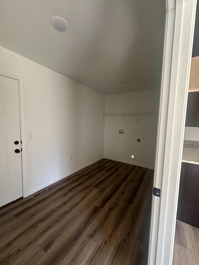 washroom with visible vents, hookup for an electric dryer, baseboards, and wood finished floors