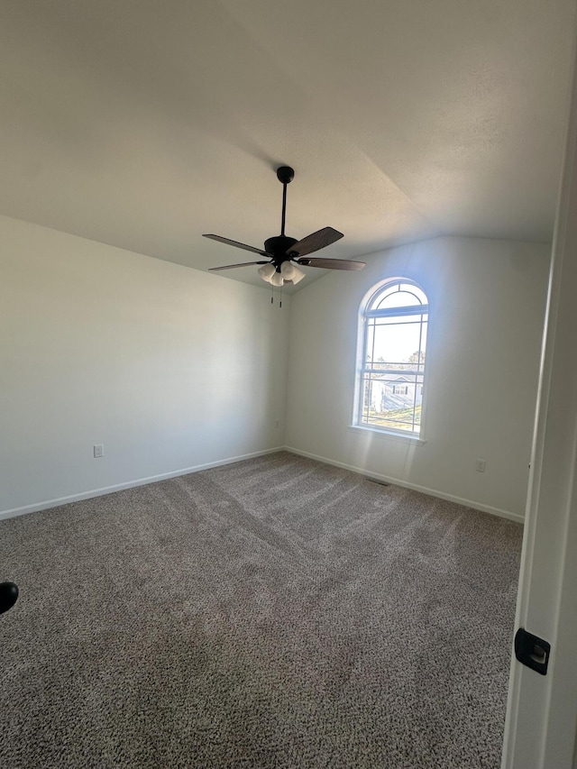 unfurnished room featuring vaulted ceiling, carpet floors, a ceiling fan, and baseboards