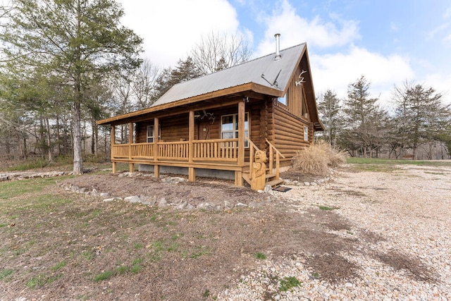 log cabin featuring covered porch