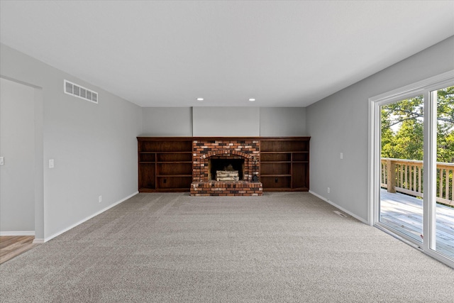 unfurnished living room featuring a brick fireplace and carpet flooring