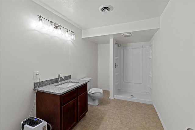 bathroom with a shower, vanity, and toilet