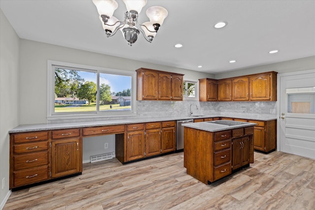 kitchen with an inviting chandelier, dishwasher, light wood-type flooring, and tasteful backsplash