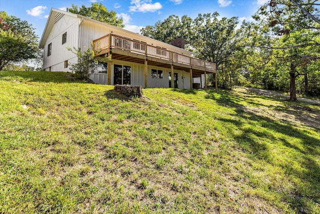 rear view of property with a deck and a lawn