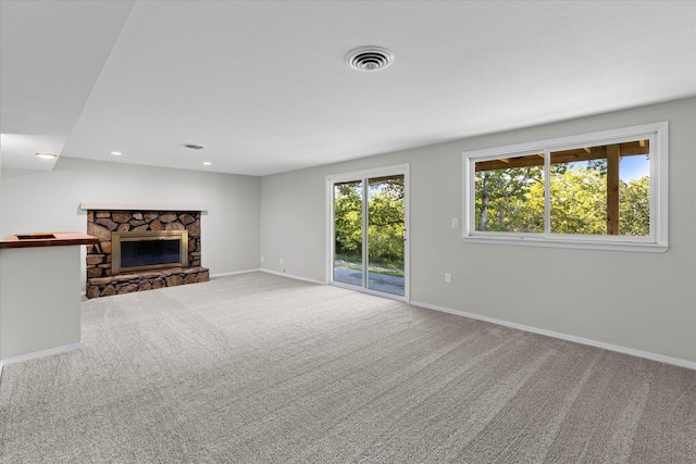 unfurnished living room with a fireplace, plenty of natural light, and carpet flooring