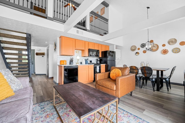 9 Scenic Ct Unit 9-9, Branson, MO 65616 - living room with stairway, wood finished floors, visible vents, high vaulted ceiling, and a notable chandelier