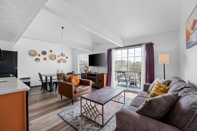 9 Scenic Ct Unit 9-9, Branson, MO 65616 - living room with lofted ceiling, a textured ceiling, wood finished floors, and an inviting chandelier