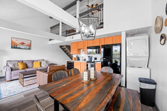 9 Scenic Ct Unit 9-9, Branson, MO 65616 - dining room featuring high vaulted ceiling, dark wood-style floors, stairway, stacked washer / dryer, and visible vents