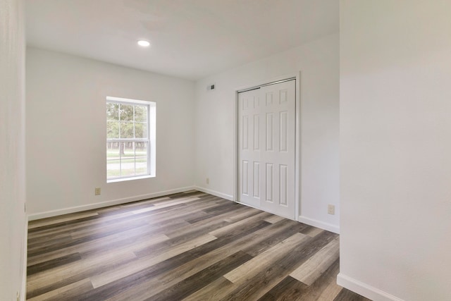 unfurnished room with dark hardwood / wood-style flooring