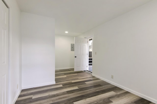 unfurnished room with recessed lighting, baseboards, electric panel, and dark wood-style floors