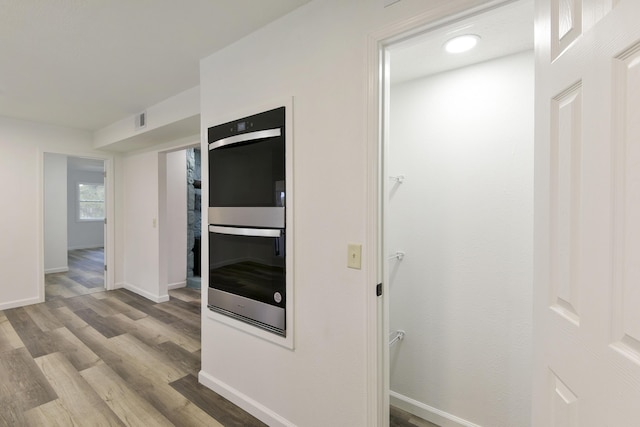 interior space with visible vents, baseboards, and wood finished floors