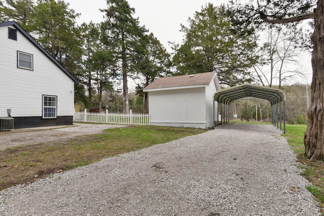 view of home's exterior with central air condition unit, a carport, and a lawn