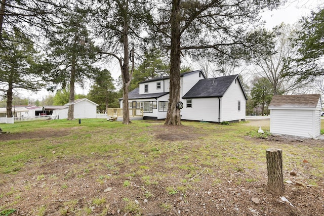 view of yard featuring fence, an outbuilding, a deck, and a storage unit
