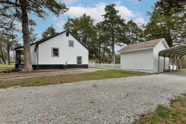 view of side of property with a carport and central AC unit