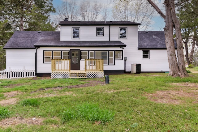 rear view of property with a yard and central air condition unit