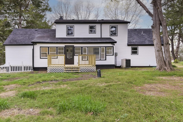 rear view of property featuring a yard, a shingled roof, a chimney, and central AC unit