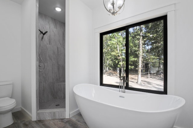 bathroom with plenty of natural light, hardwood / wood-style floors, separate shower and tub, and toilet