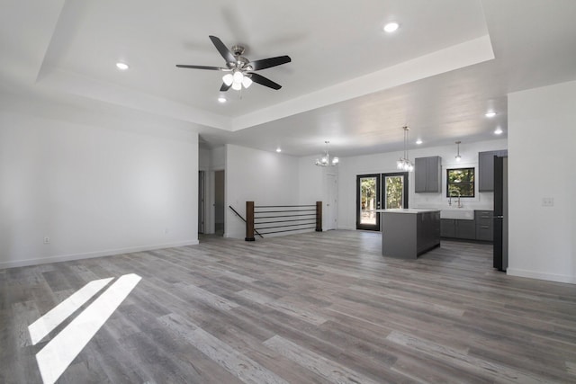 000 State Route Jj, West Plains, MO 65775 - unfurnished living room with a sink, wood finished floors, ceiling fan with notable chandelier, a tray ceiling, and recessed lighting