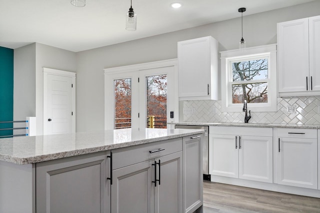 000 State Route Jj, West Plains, MO 65775 - kitchen with white cabinets, a center island, light wood finished floors, and tasteful backsplash