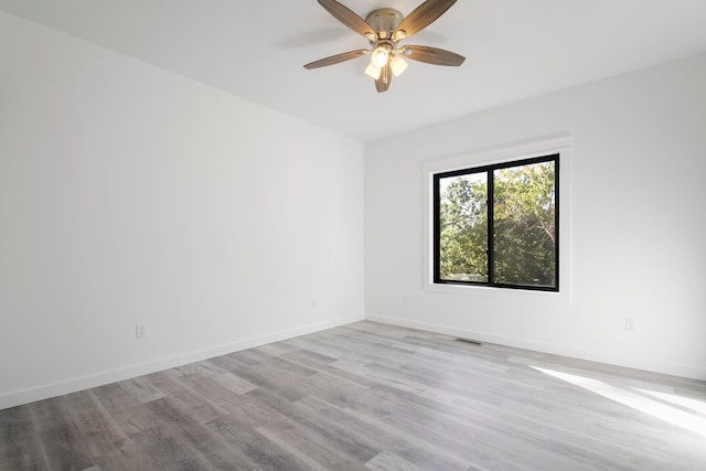 empty room with ceiling fan and light hardwood / wood-style floors