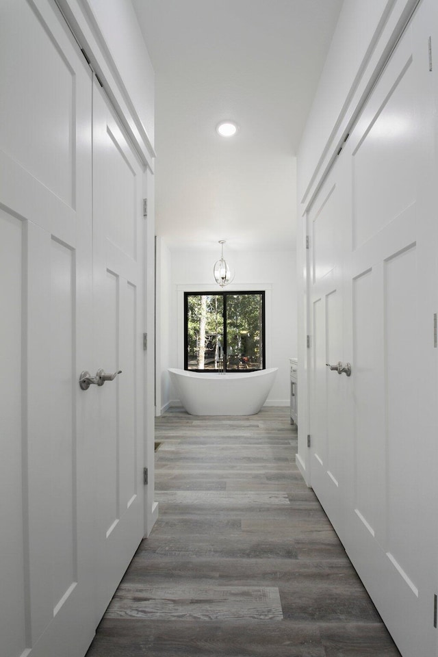 hall with hardwood / wood-style floors and an inviting chandelier