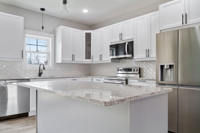 000 State Route Jj, West Plains, MO 65775 - kitchen with white cabinets, stainless steel appliances, backsplash, a kitchen island, and pendant lighting