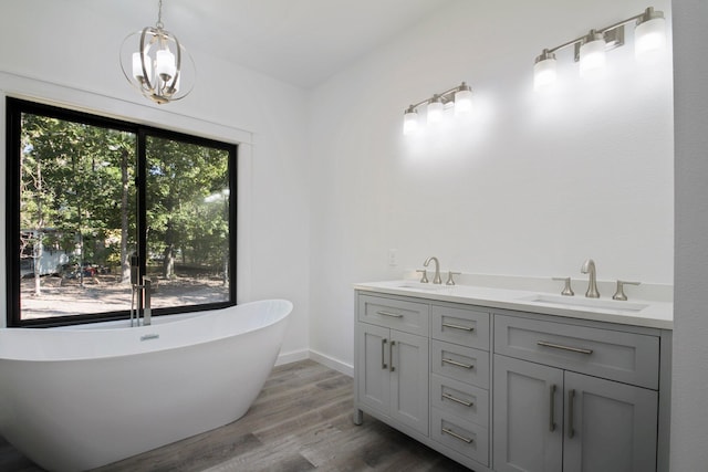 000 State Route Jj, West Plains, MO 65775 - full bathroom with a soaking tub, a sink, double vanity, a notable chandelier, and wood finished floors