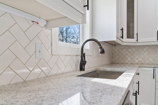 000 State Route Jj, West Plains, MO 65775 - kitchen with white cabinets, a sink, backsplash, glass insert cabinets, and light stone countertops