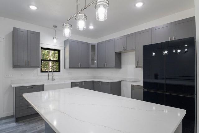 000 State Route Jj, West Plains, MO 65775 - kitchen featuring wood finished floors, gray cabinets, a sink, light stone countertops, and a center island