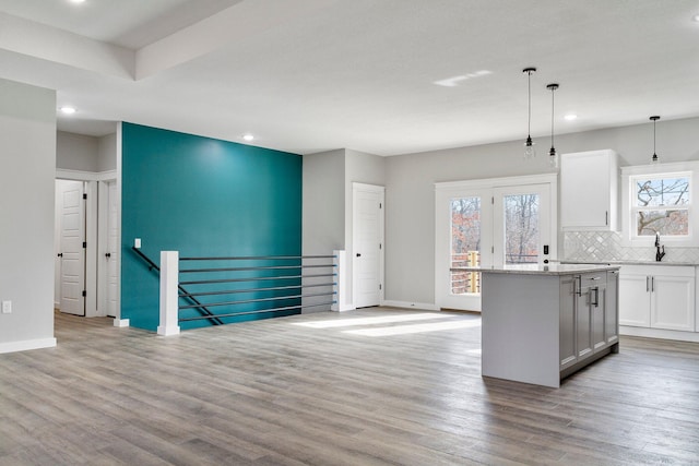 kitchen with hanging light fixtures, light hardwood / wood-style flooring, plenty of natural light, and a kitchen island