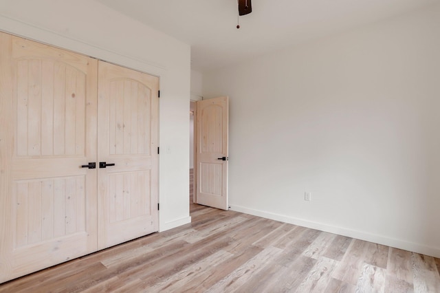 unfurnished bedroom featuring ceiling fan, light hardwood / wood-style flooring, and a closet