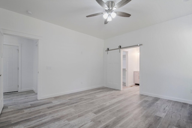 000 State Route Jj, West Plains, MO 65775 - spare room featuring a ceiling fan, baseboards, light wood-style flooring, and a barn door