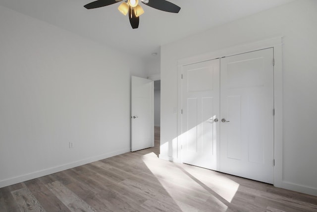 unfurnished bedroom featuring light wood-type flooring, ceiling fan, and a closet