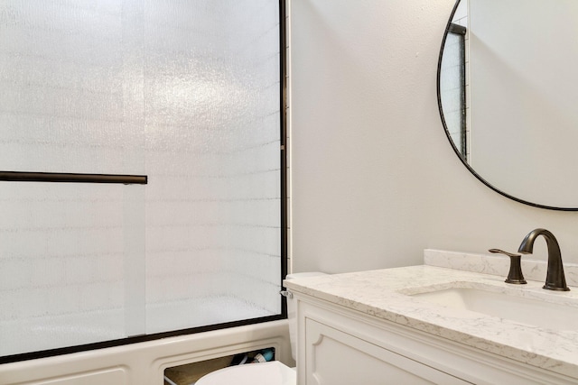 bathroom with walk in shower, vanity, and toilet