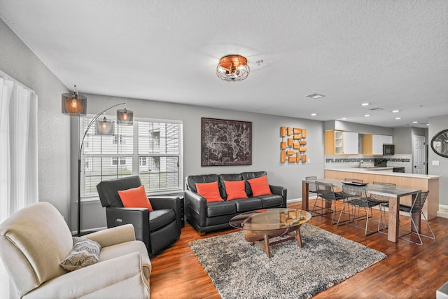 living room with hardwood / wood-style floors and a textured ceiling